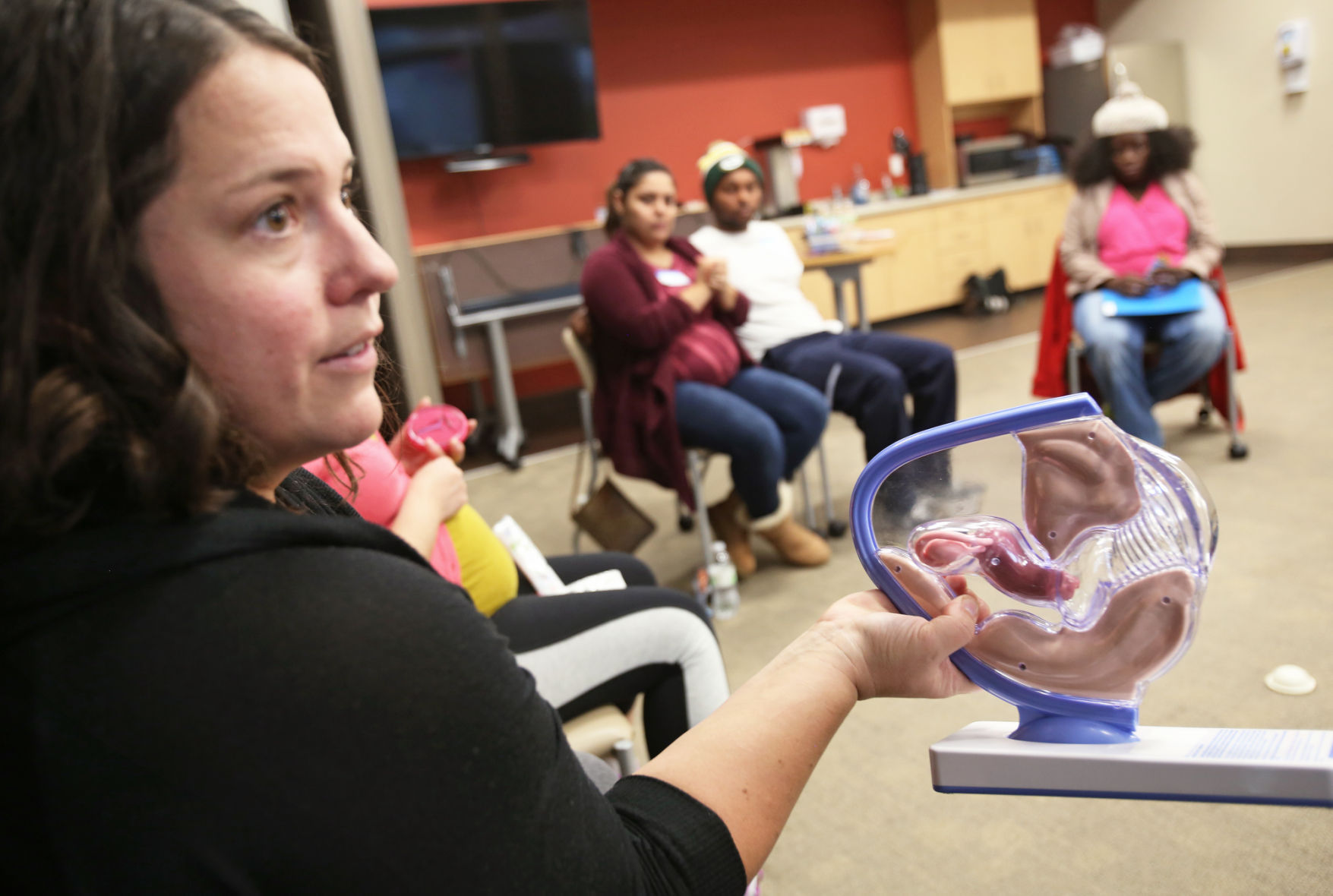 Emily Beaman holding female pelvis model